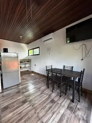 a room with a table and chairs and a flat screen tv at Cabinas Guacamaya Cabuya - 2 cuartos in Cabuya
