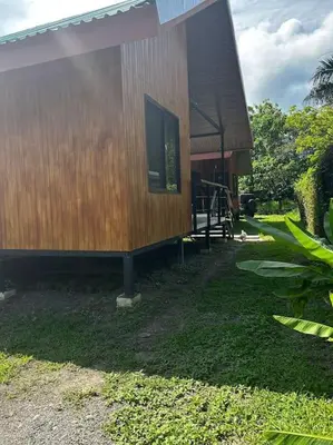 a small house with a large window on the side of it at Cabinas Guacamaya Cabuya - 2 cuartos in Cabuya