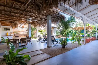 a dining room with a table and some plants at Casa Karibe in Tamarindo