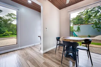 a dining room with a table and chairs and a large window at Monte Donato 18 - Apt 1 in Playa Avellana