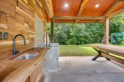 an outdoor kitchen with a sink and a bench at Monte Donato 18 - Apt 1 in Playa Avellana