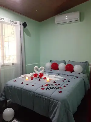a bedroom with a bed with roses and candles on it at Angel Bee Lodge in Fortuna
