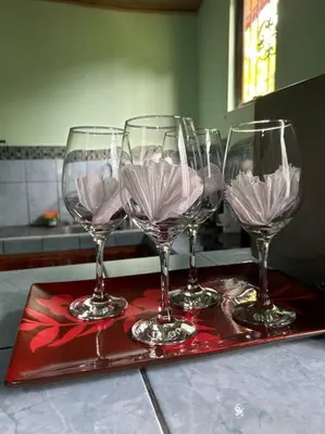 four wine glasses on a red tray on a counter at Angel Bee Lodge in Fortuna
