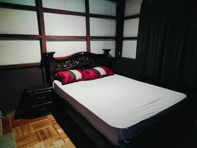 a bed in a room with a large window at Posada Familiar Rìo Celeste in San Rafael