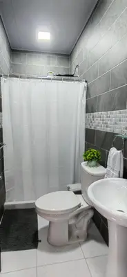 a bathroom with a white toilet and a sink at APARTAMENTOs HABY 2 in Paquera