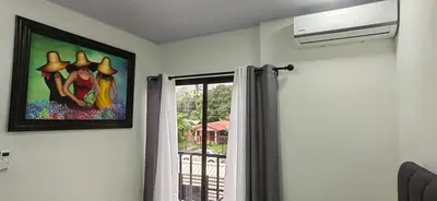 a painting hanging on a wall next to a window at APARTAMENTOs HABY 2 in Paquera