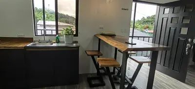 a kitchen with a counter and a sink and a table at APARTAMENTOs HABY 2 in Paquera