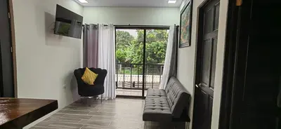 a hallway with a chair and a door with a balcony at APARTAMENTOs HABY 2 in Paquera