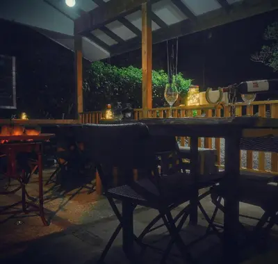 a table and chairs on a patio at night at Finca Queveri in Orosí