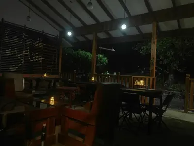 a restaurant with tables and chairs at night at Finca Queveri in Orosí