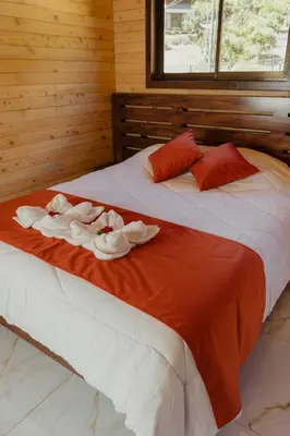 a bedroom with two beds with towels on them at Cabinas El Quetzal in San Gerardo de Dota