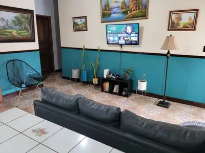 a living room with a black couch and a tv at Casa Chelis in Fortuna