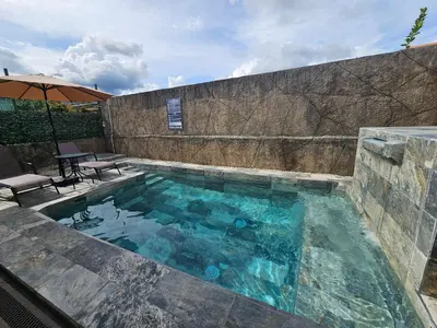 a swimming pool with a table and an umbrella at Casa Chelis in Fortuna