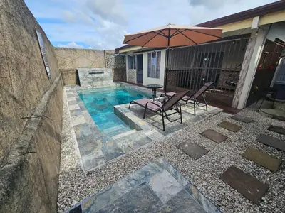 a swimming pool with two chairs and an umbrella at Casa Chelis in Fortuna