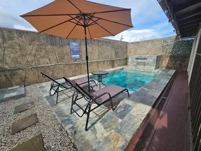 a table and chairs with an umbrella next to a swimming pool at Casa Chelis in Fortuna