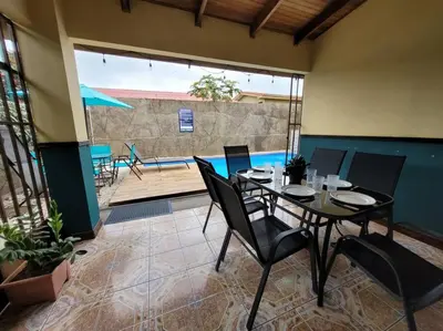 a dining room with a table and chairs and a pool at Casa Chelis in Fortuna