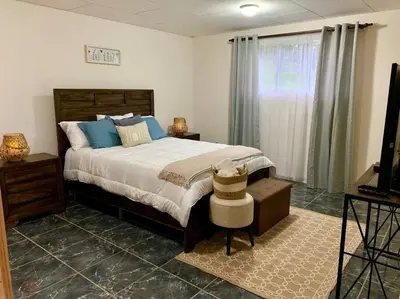 a bedroom with a bed with blue pillows and a television at Country house with an incredible view to the city in Cartago