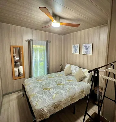 a bedroom with a bed with a ceiling fan at Bungalows at Residencias Arenal in Fortuna