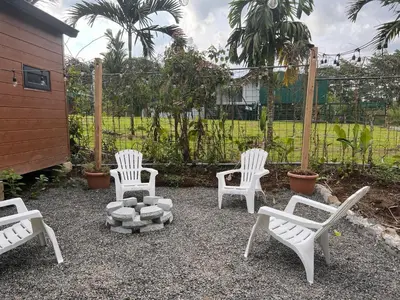 a group of white chairs sitting in a yard at Bungalows at Residencias Arenal in Fortuna