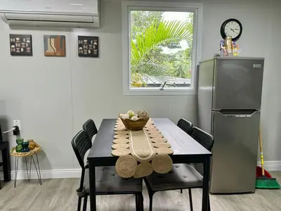 a dining room with a table and a refrigerator at Bungalows at Residencias Arenal in Fortuna