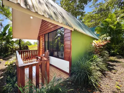 a small house with a porch and a balcony at Oro Verde Lodge in Fortuna