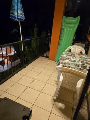a table and chairs on a balcony with an umbrella at Condominio Coco Marindo #34 in Coco