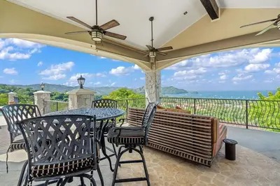 a patio with a table and chairs and a view of the ocean at Luxurious 3 Bedroom Villa in Coco