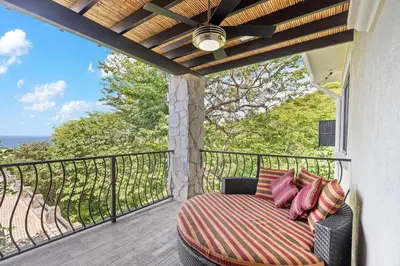 a bed on a balcony with a view of the ocean at Luxurious 3 Bedroom Villa in Coco