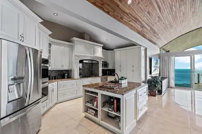 a kitchen with white cabinets and stainless steel appliances at Luxury Retreat Oceanview w Fitness Studio in Playa Hermosa