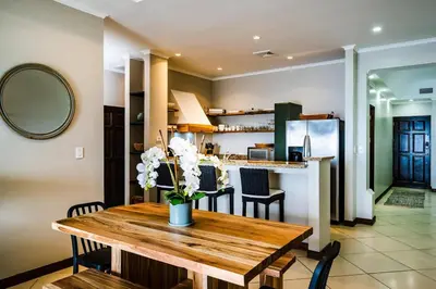 a kitchen and dining room with a wooden table at Ocean-Views, Infinity Pools & Private Veranda in Playa Flamingo