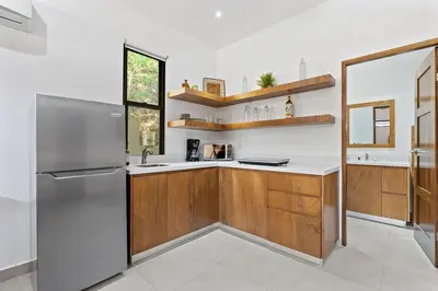 a kitchen with wooden cabinets and a stainless steel refrigerator at Infinity Edge Pool Oceanview 4 BR 4BA in Brasilito