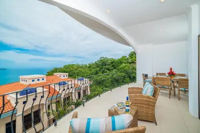 a balcony with chairs and a view of the ocean at Spectacular Ocean View Condo in Playa Flamingo