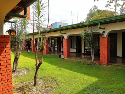 a building with two trees in front of it at Hotel Wagelia Turrialba in Turrialba