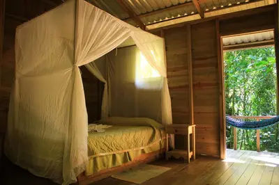 a bedroom with a canopy bed in a cabin at Hotel Wagelia Espino Blanco in Turrialba