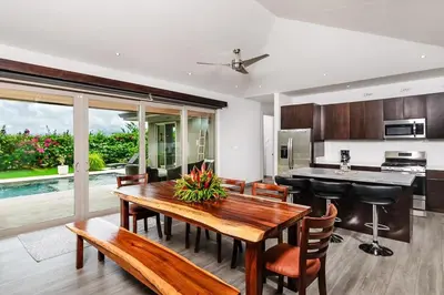 a kitchen and dining room with a wooden table and chairs at Contemporary Villa 3 BD 3BA Pool in Playa Flamingo