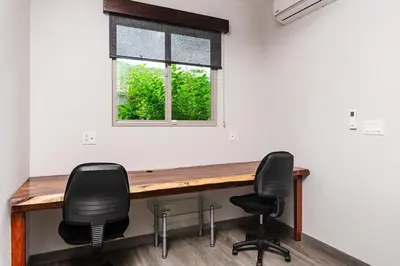 a desk in a room with two chairs and a window at Contemporary Villa 3 BD 3BA Pool in Playa Flamingo