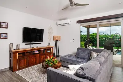 a living room with a couch and a flat screen tv at Contemporary Villa 3 BD 3BA Pool in Playa Flamingo