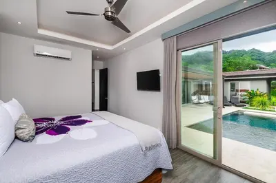 a bedroom with a bed and a swimming pool at Contemporary Villa 3 BD 3BA Pool in Playa Flamingo