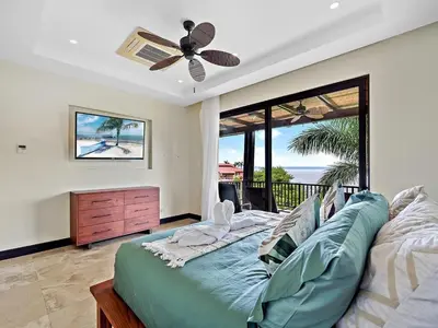 a bedroom with a bed and a ceiling fan at Spacious Ocean View 3 bd Condo w - Pool in Ocotal