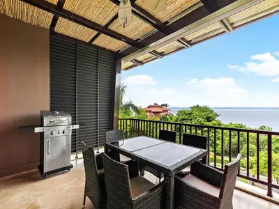 a patio with a table and chairs on a balcony at Spacious Ocean View 3 bd Condo w - Pool in Ocotal