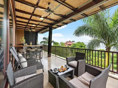a patio with chairs and tables on a balcony at Spacious Ocean View 3 bd Condo w - Pool in Ocotal