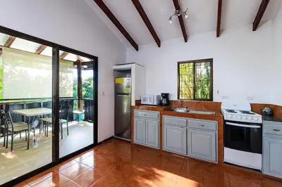 a kitchen with a sink and a stove and a table at Studio, Free Concierge & Walk to Tamarindo Beach in Tamarindo
