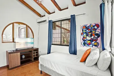 a bedroom with a bed and a dresser and a window at Studio, Free Concierge & Walk to Tamarindo Beach in Tamarindo
