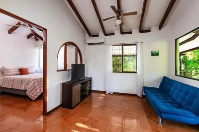 a living room with a blue couch and a bed at Studio, Free Concierge & Walk to Tamarindo Beach in Tamarindo