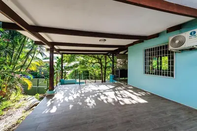 an empty patio with a blue wall and trees at Studio, Free Concierge & Walk to Tamarindo Beach in Tamarindo
