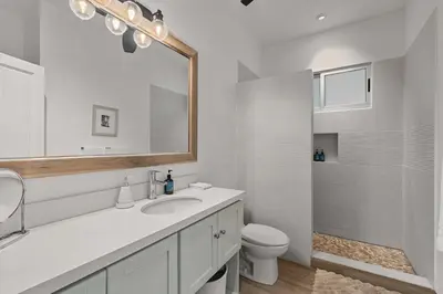 a bathroom with a sink and a toilet and a mirror at 7 min walk to Surfing Paradise, Pool & Ocean Fun in Playa Grande