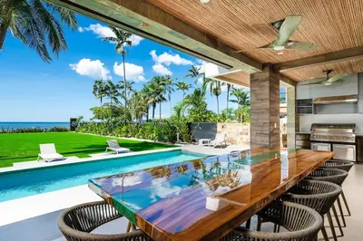 an outdoor dining area with a table and chairs and a swimming pool at Beachfront Luxury Villa, 2 Pools & Daily Breakfast in Playa Flamingo