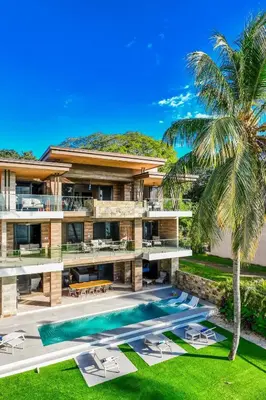 an exterior view of a house with a swimming pool at Beachfront Luxury Villa, 2 Pools & Daily Breakfast in Playa Flamingo