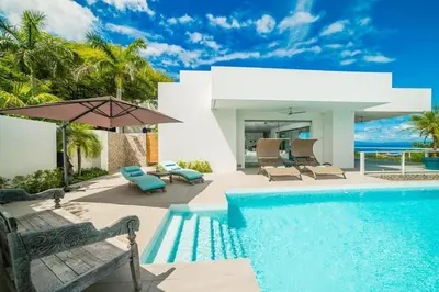a villa with a swimming pool and a house at Ocean-View Villa, Pool & Concierge in Ocotal
