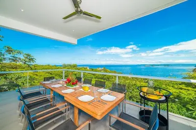 a dining room with a table and chairs on a balcony at Ocean-View Villa, Pool & Concierge in Ocotal